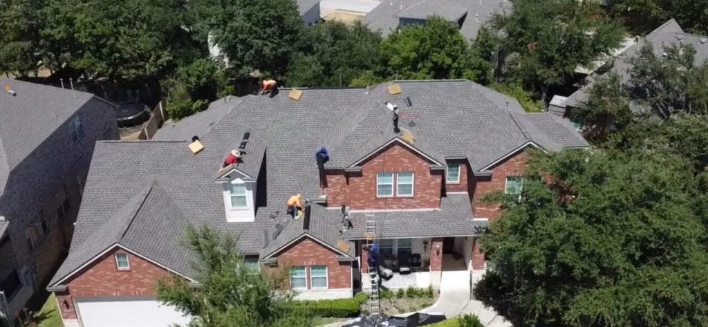 Roofing crew working on a shingle roof