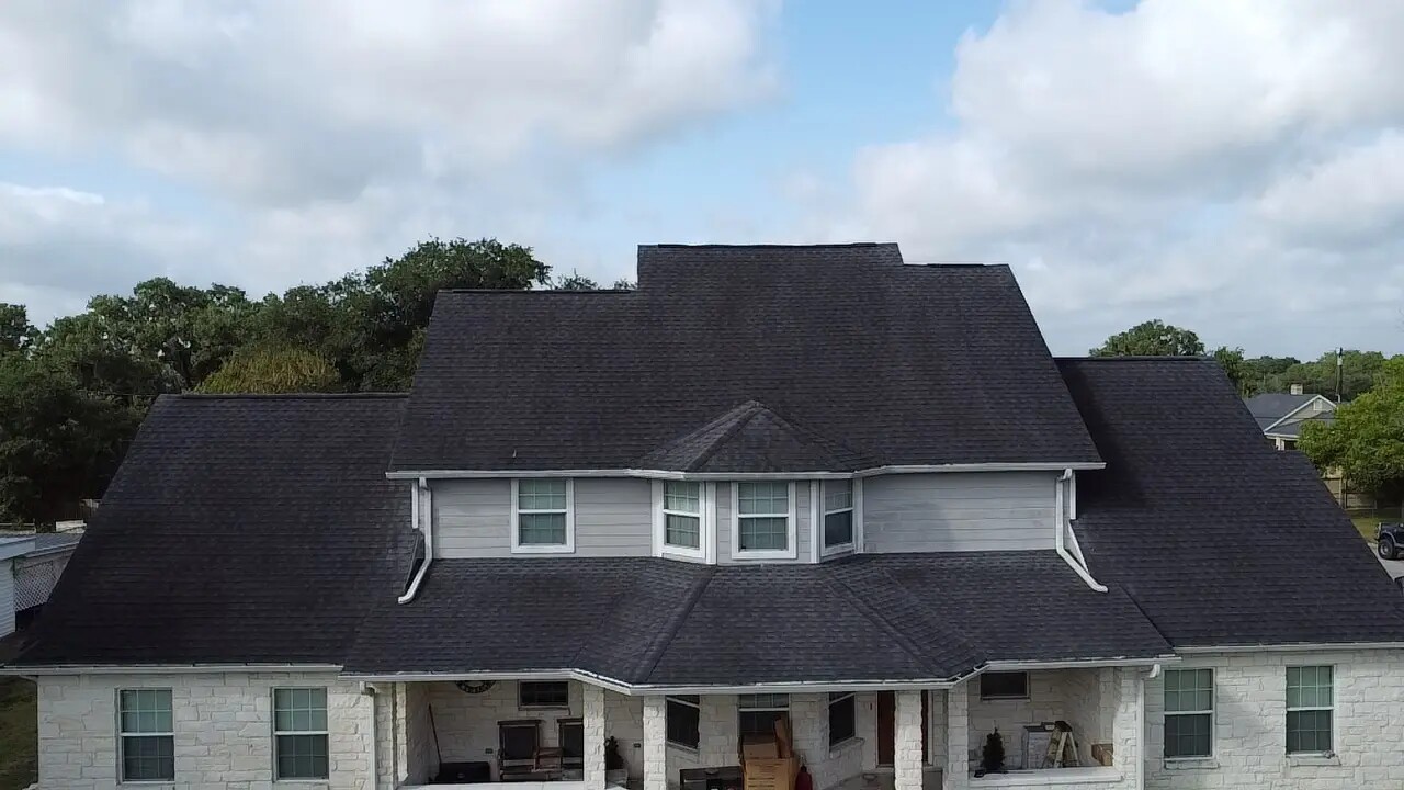 Large home with a completed dark shingle roof